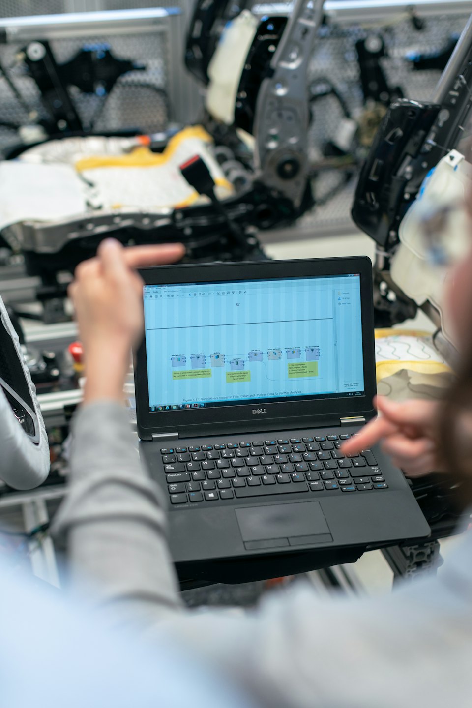 Dos personas revisando un diagrama de flujo de datos en la pantalla de un portátil.